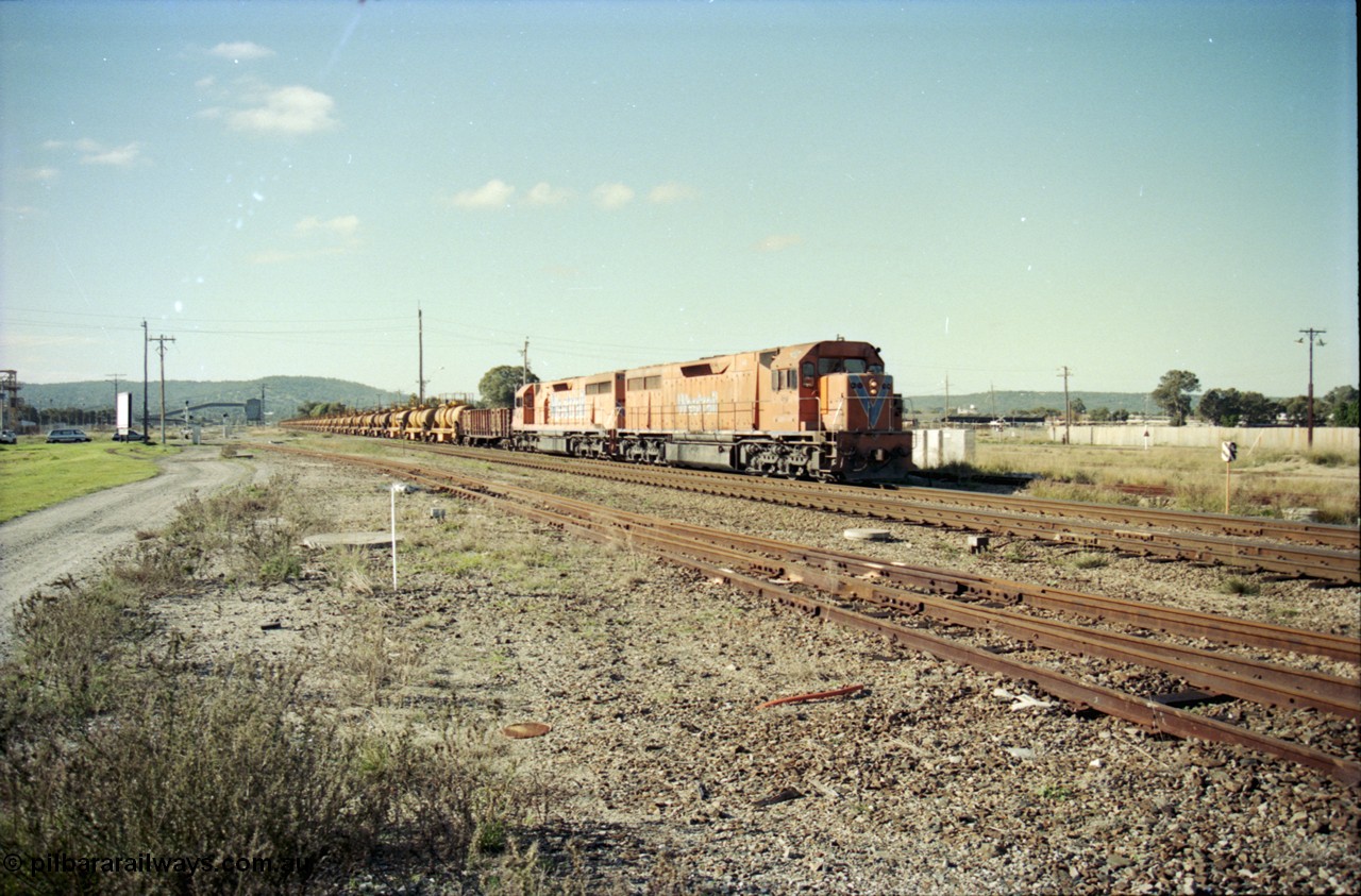 186-14
Midland, Westrail standard gauge up Kalgoorlie loaded acid train 428 crosses Lloyd Street behind a pair of L class locomotives L 268 Clyde Engineering EMD model GT26C serial 68-617 and L 256 serial 67-546, with the dual gauge track to the Flashbutt Yard in the foreground. The empty return working of this train was 027 empty acid.
Keywords: L-class;L258;Clyde-Engineering-Granville-NSW;EMD;GT26C;68-548;