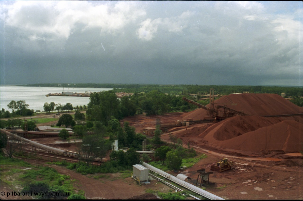 211-07
Weipa, Lorim Point, view from kaolin storage silos looking at Even's Landing in the background and the shiploading stockpile area of bauxite on the right while a storm threatens in the distance.

