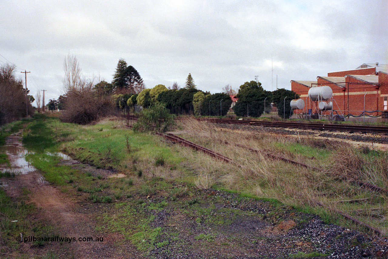 107-05
Kyabram track view, rails for Kyabram Fruit Packers siding, Kyabram Co-op Fruit Preserving Company on the right, looking towards Kyabram.
