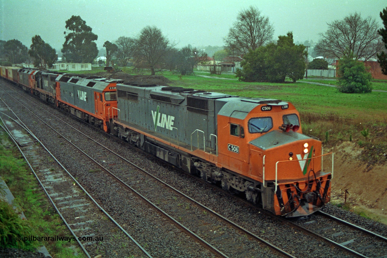 113-04
Ballarat East loco depot, V/Line broad gauge up Adelaide goods train 9150 behind the quad CGCG combo of C class C 506 Clyde Engineering EMD model GT26C serial 76-829, G class G 538 Clyde Engineering EMD model JT26C-2SS serial 89-1271, C class C 510 serial 76-833, G class G 513 serial 85-1241, in miserable conditions, poor quality, taken from footbridge.
Keywords: C-class;C506;Clyde-Engineering-Rosewater-SA;EMD;GT26C;76-829;