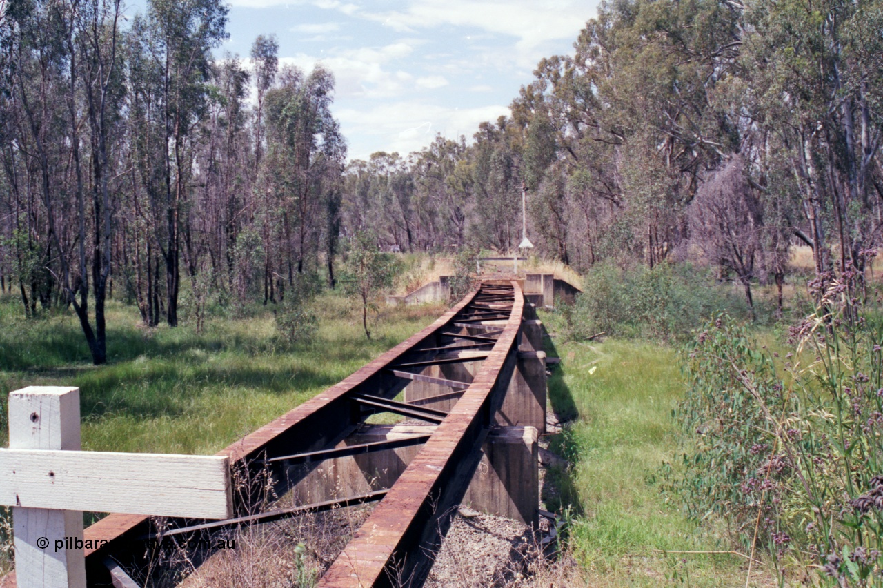 118-16
Tocumwal line, view of bridge looking north towards Tocumwal, down home signal mast and location board visible on far side of bridge, line out of service. [url=https://goo.gl/maps/Hvzxa15CUzFiCYKL6]Geo data[/url].
