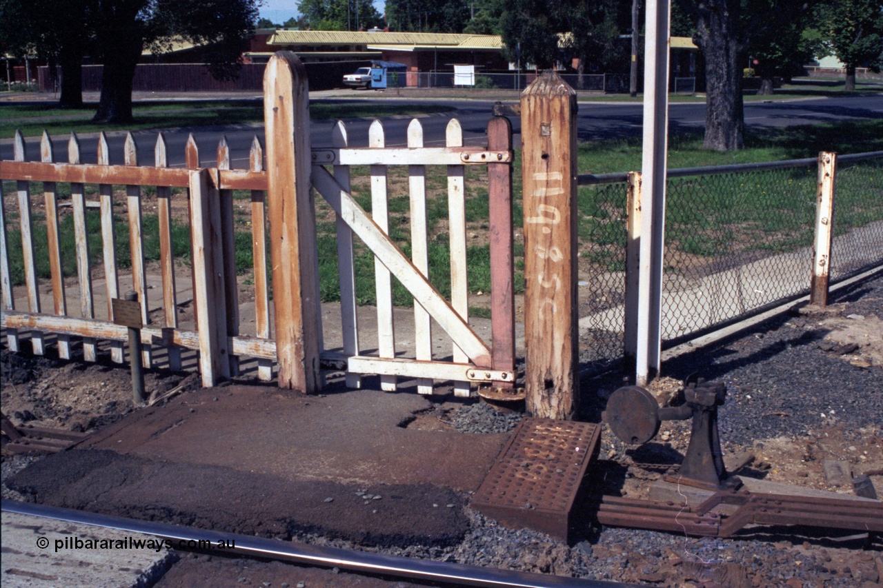 140-1-25
Ballarat North or C Signal Box, pedestrian gate at Macarthur St, the weight keeps the gate closed, point rodding, post is painted 119.85 C for 119 miles and 85 chains from Melbourne.
