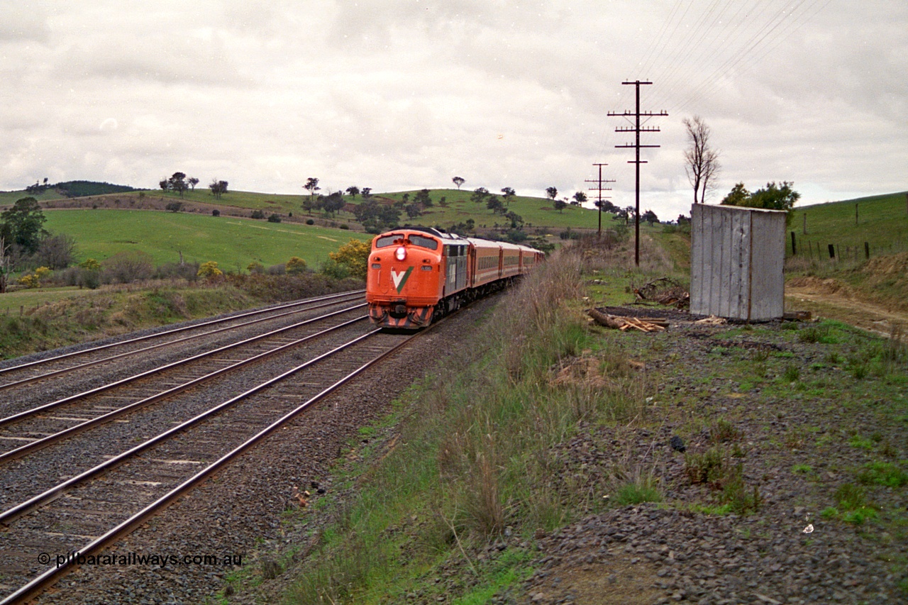 166-17
Wandong, down broad gauge V/Line passenger train behind rebuilt Bulldog A class A 66 Clyde Engineering EMD model AAT22C-2R serial 84-1186 rebuilt from B class B 66 Clyde Engineering EMD model ML2 serial ML2-7 with an N set near the site of Mathiesons Siding and O'Gradys Road grade crossing, the far track is the standard gauge line.
Keywords: A-class;A66;Clyde-Engineering-Rosewater-SA;EMD;AAT22C-2R;84-1186;rebuild;bulldog;