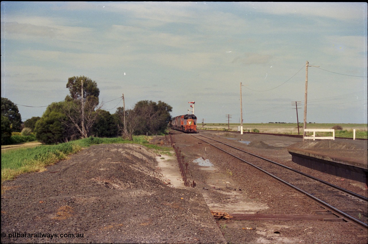 179-11
Gheringhap, yard view looking east towards Geelong, V/Line broad gauge goods train 9169 is approaching the station, taken from form up platform, point rodding can be seen leaving the signal box.
