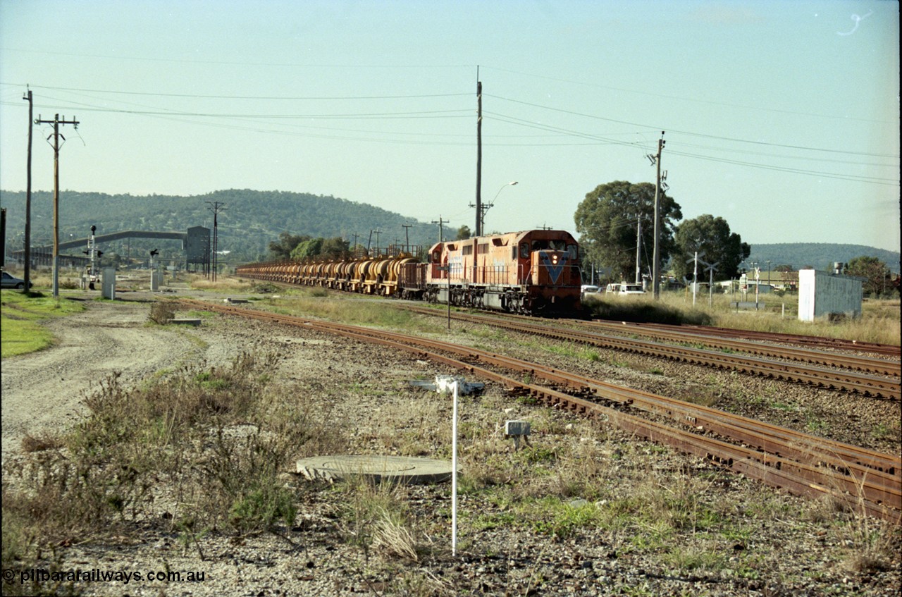 186-13
Midland, Westrail standard gauge up Kalgoorlie loaded acid train 428 crosses Lloyd Street behind a pair of L class locomotives L 258 Clyde Engineering EMD model GT26C serial 68-548 and L 256 serial 67-546, with the dual gauge track to the Flashbutt Yard in the foreground. The empty return working of this train was 027 empty acid.
Keywords: L-class;L258;Clyde-Engineering-Granville-NSW;EMD;GT26C;68-548;