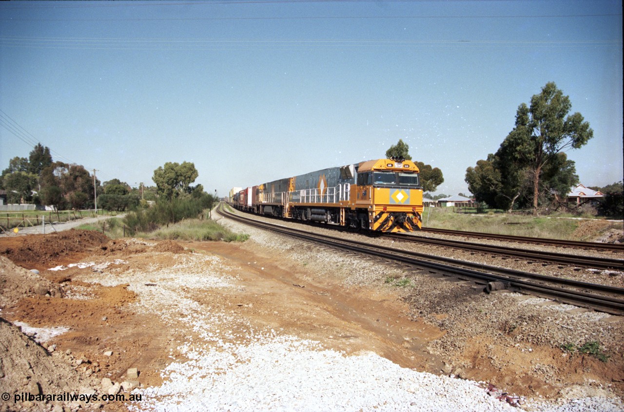 186-21
Woodbridge, a very clean and new looking NR class NR 100, a Goninan built GE model Cv40-9i serial 7250-07/97-304 leads a sister unit with National Rail intermodal train 4MP5 at Woodbridge Rd grade crossing.
Keywords: NR-class;NR100;Goninan;GE;Cv40-9i;7250-07/97-304;