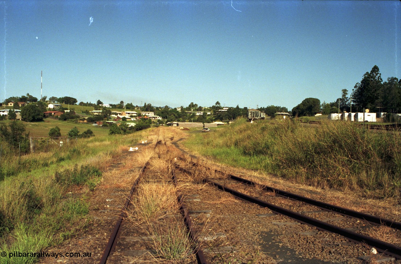 187-15
Monkland, Gympie Queensland. View looking east into the lower yard, overgrown. Molasses tanks in upper yard at unloading siding. [url=https://goo.gl/maps/bcrsBh862ys]GeoData[/url].
