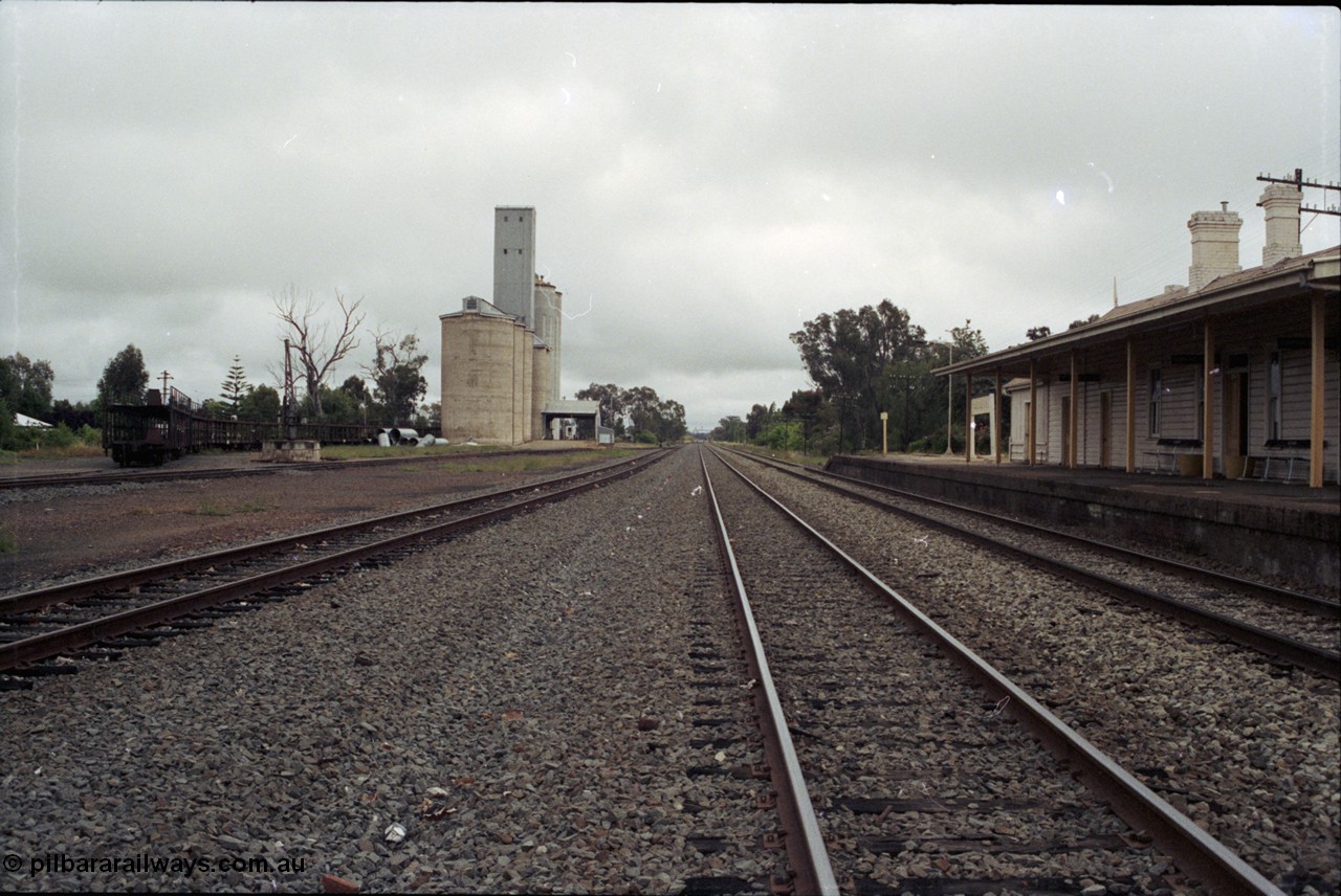 188-02
Culcairn, 596 km from Sydney on the NSW Main South, view of station yard looking north, stored car carrying waggons in grain loop with crane visible in front, station platform and building on the right. Reverse view of 188-01. Geo [url=https://goo.gl/maps/aQzJi3mNY3t]Data[/url].
