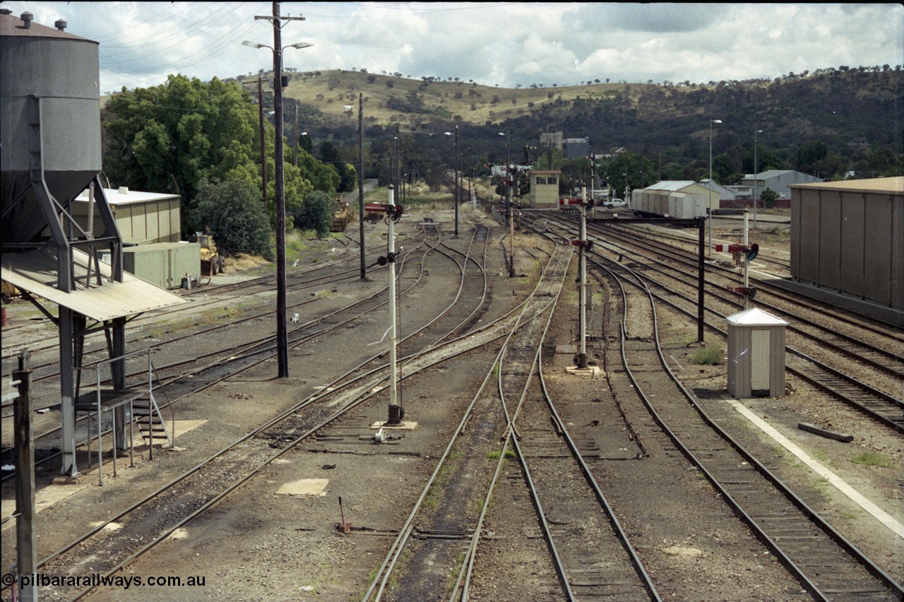 190-02
Cootamundra, NSW Main South, looking south from the pedestrian footbridge, loco depot and sanding tower on the left, South signal box in the distance with a rake of NTBX vans.
