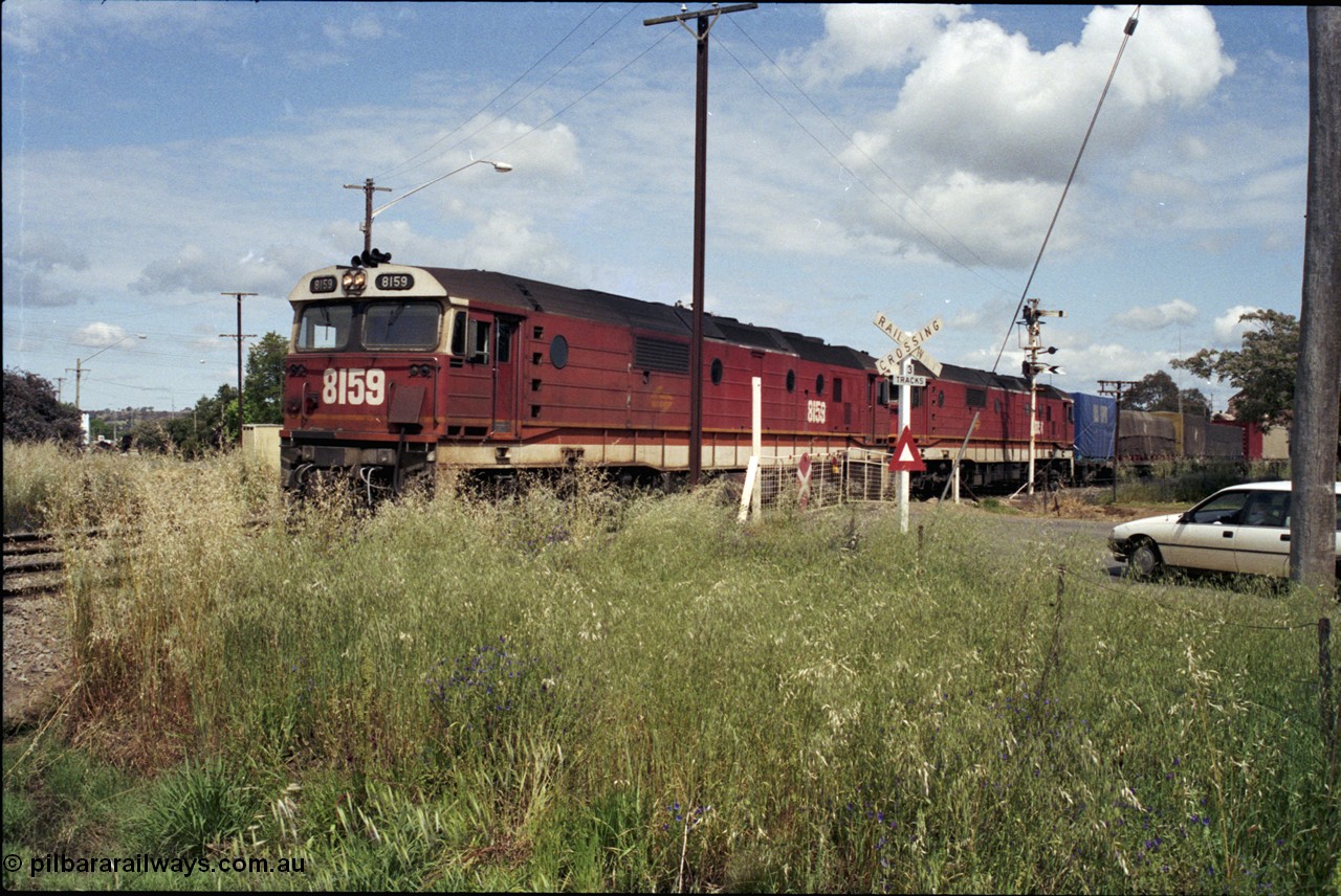 190-24
Cootamundra West, NSW located 431 km from Sydney and the start of the Lake Cargelligo branchline, a Perth bound interstate freight train taking the scenic route, via Cootamundra West, Stockinbingal and Parkes, passes over Yass Road through the manual hand gates behind 81 class locomotive 8159 and a sister unit.
Keywords: 81-class;8159;Clyde-Engineering-Kelso-NSW;EMD;JT26C-2SS;84-1078;