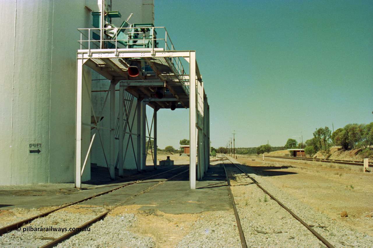 202-17
Meckering, looking east, the three loadout spouts for the concrete grain silos, DRIFT sign to indicate the grade when loading waggons, station at right and goods shed visible beyond the loadout.
