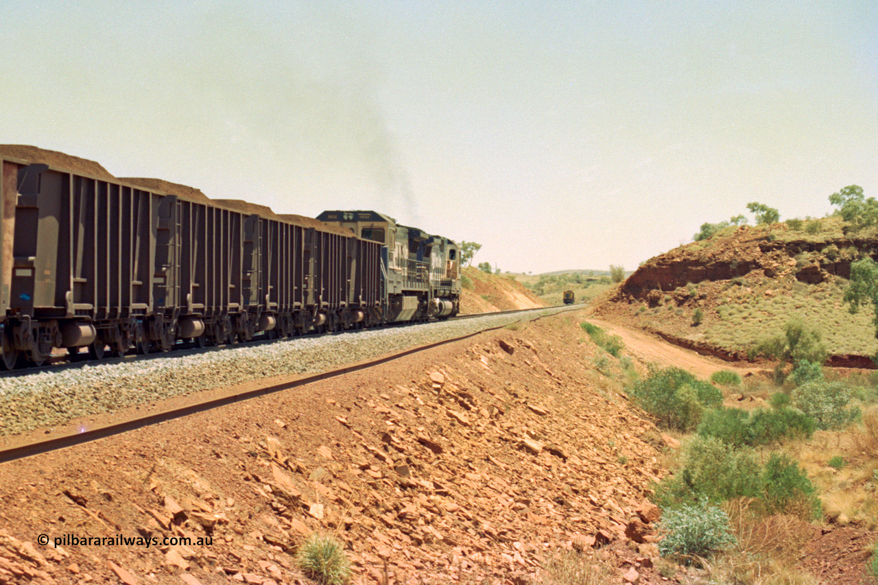 202-29
Yandi One, 307 km grade crossing sees a loaded train departing behind a CM40-8M and an CM40-8 unit with the rail grinder in the back track in the distance.
