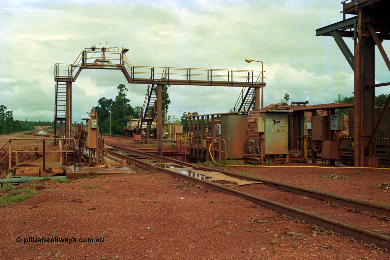 210-02
Weipa, Lorim Point, Comalco rail dump station, view looking towards Andoom Mine, shows inspection walkway and opening for unloading hopper, the waggons are discharged on the right track.
