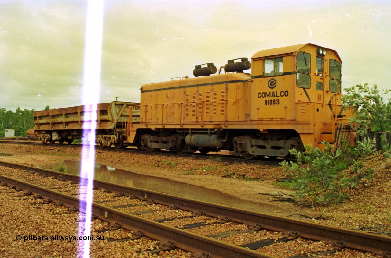 210-10
Weipa, Lorim Point railway workshops. Comalco shunt engine R 1003 coupled to a Difco side dump waggon. R 1003 is an Electro Motive built NW2 model with serial number 4114 and frame number of E761-8 was built in November 1946 at La Grange originally for Canadian National with road number 7943. Sold to Comalco in December 1975 and entered service in 1976. This unit was subsequently scrapped in 2000.
Keywords: R1003;EMD;NW2;4114;E761-8;Comalco;Canadian-National;