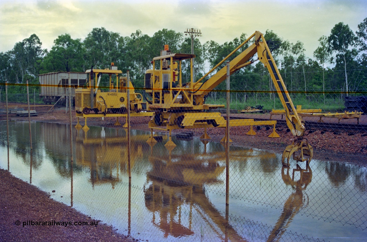 210-17
Weipa, Lorim Point track maintenance compound, sleeper handler crane and a sleeper scarifier - inserter beside it numbered R 4015, ballast waggon R 4003 in the background.
Keywords: Comalco;