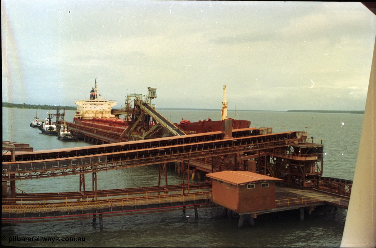 211-30
Weipa, Lorim Point overview looking south east from the kaolin loader at no. 2 berth showing berth construction, tug boats, no. 2 bauxite loader and the TNT Capricornia, a coal fired 75,500-dwt bulk carrier built by Italcantieri for TNT Bulkships trade run between Gladstone and Weipa.
