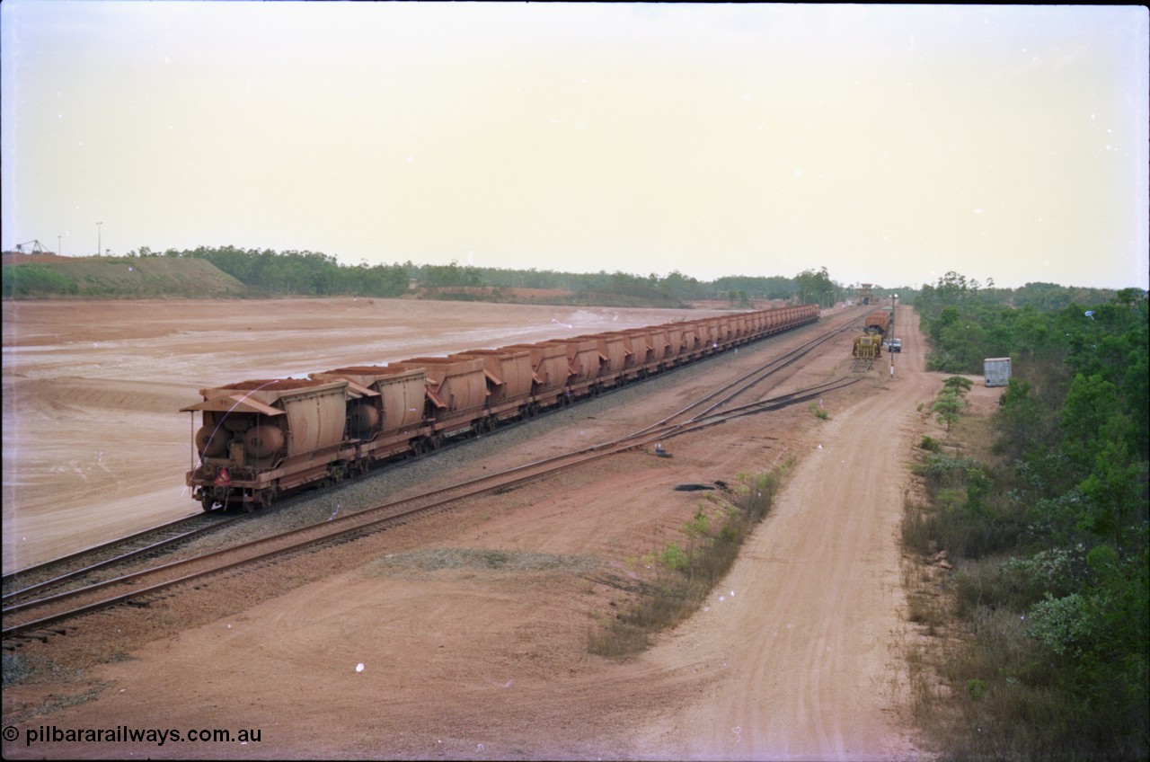 212-23
Weipa, a loaded train ex-Andoom Mine runs along the main with thirty two waggons at Lorim Point towards the dump station behind Comalco R 1001 Clyde Engineering built EMD model GT26C serial 72-752 originally numbered 1.001 and built in 1972. July 1995.
