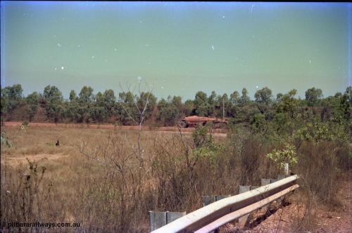 212-03
Weipa, Lorim Point, view of articulated haulpak on haul road from overbridge.
