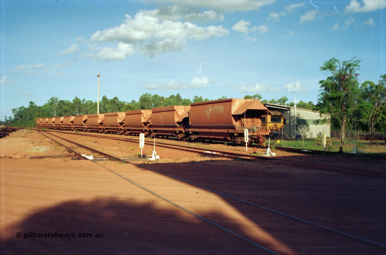 213-00
Weipa, Lorim Point Workshops looking east across to the track maintenance compound with eleven Comalco ore waggons of both types lined up and the Speno rail grinder in the compound, September 1995.
