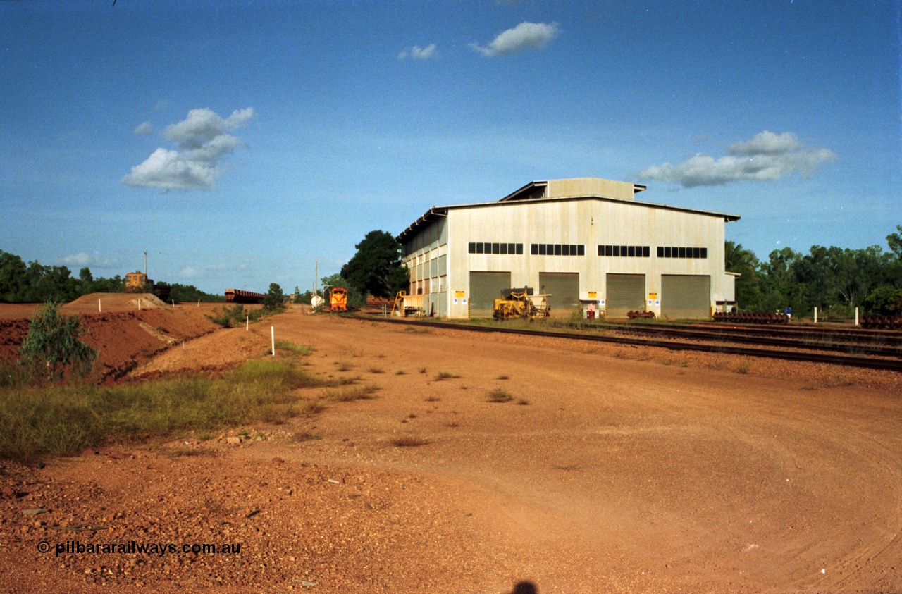 213-16
Weipa, Lorim Point workshops building, looking south east at the rear of the building and yard. From the left, R 1003, waggons, R 1001 and the Canron Rail Group Mk I switch tamper.
