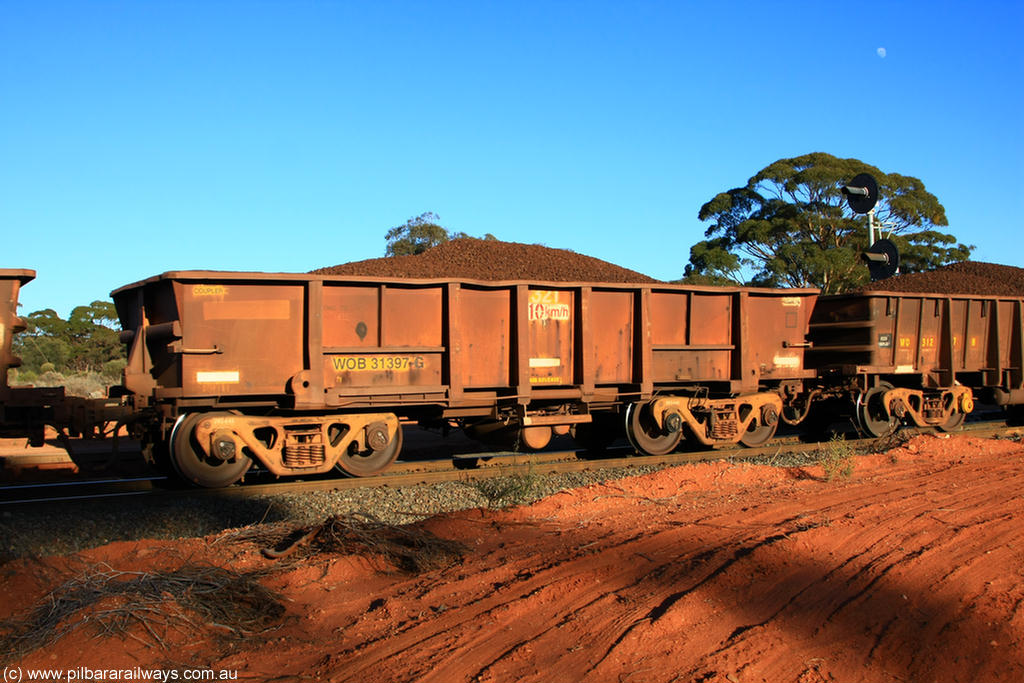 100731 02356
WOB type iron ore waggon WOB 31397 is one of a batch of twenty five built by Comeng WA between 1974 and 1975 and converted from Mt Newman high sided waggons by WAGR Midland Workshops with a capacity of 67 tons with fleet number 321 for Koolyanobbing iron ore operations. This waggon was also converted to a WSM type ballast hopper by re-fitting the cut down top section and having bottom discharge doors fitted, converted back to WOB in 1998, on loaded train 6413 at Binduli Triangle, 31st July 2010.
Keywords: WOB-type;WOB31397;Comeng-WA;WSM-type;Mt-Newman-Mining;