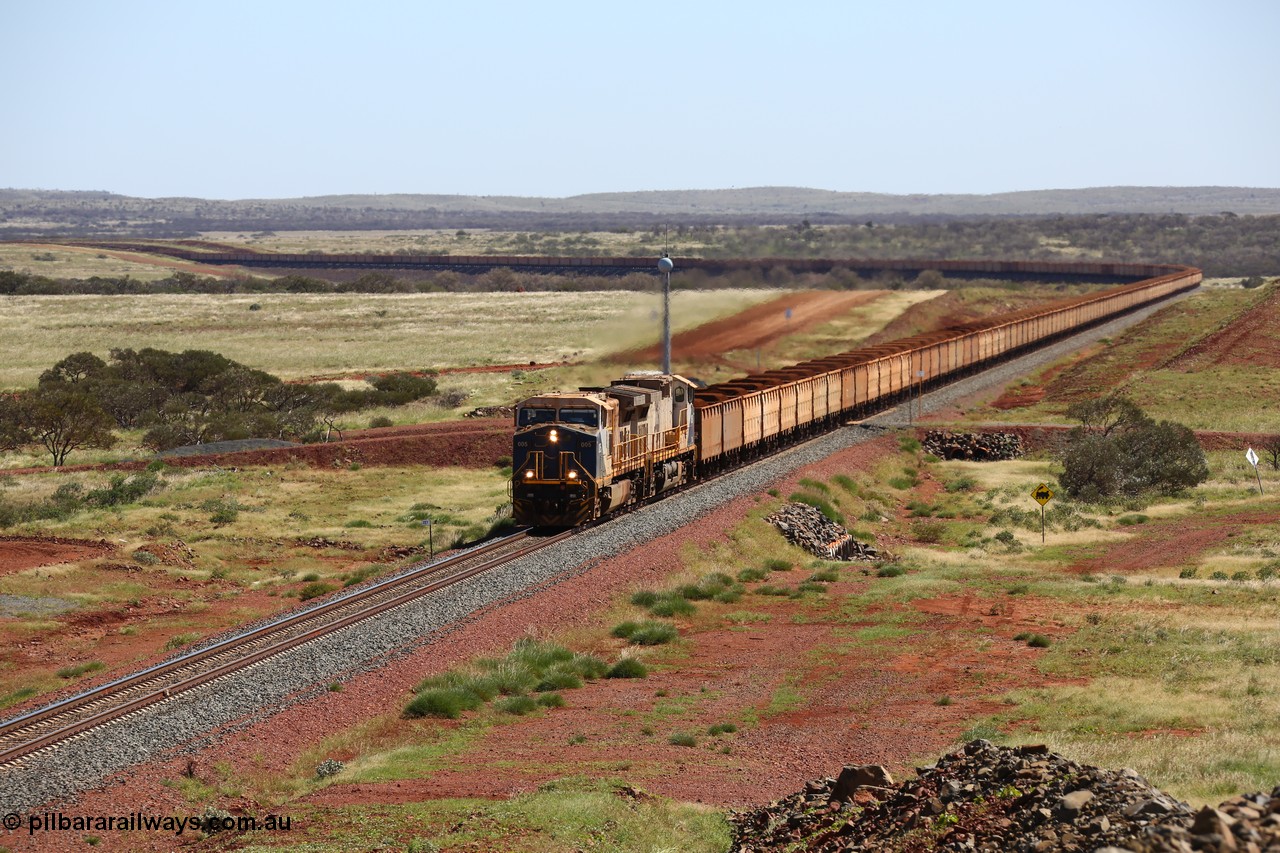 150505 7956
FMG Solomon Line, a pair of General Electric Dash 9-44CW locomotives 005 serial 58182 and 006 serial 58183 struggle upgrade with a loaded train at the 227 km bound for Port Hedland, the train is being assisted in the rear. Geodata: [url=https://goo.gl/maps/NjHo38Gc7kE2] -22.0189283 118.5861050 [/url].
Keywords: FMG-005;GE;Dash-9-44CW;58182;FMG-006;58183;