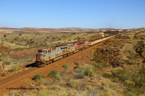 170728 09855
Western Creek - Emu area, Rio Tinto's General Electric built ES44DCi class leader 8100 serial 57996 leads two sister units, in 8176 and 8143 both in the later Rio Tinto stripe livery, with a loaded train running down from Emu Siding on the line to Dampier. The disabled Mesa A train is still on the bridge, the line to the left of the loaded is the Robe River Western Creek - Emu interconnecting line. July 28, 2017. [url=https://goo.gl/maps/vvUWXEgppNM2]GeoData[/url].
Keywords: 8100;GE;ES44DCi;57996;