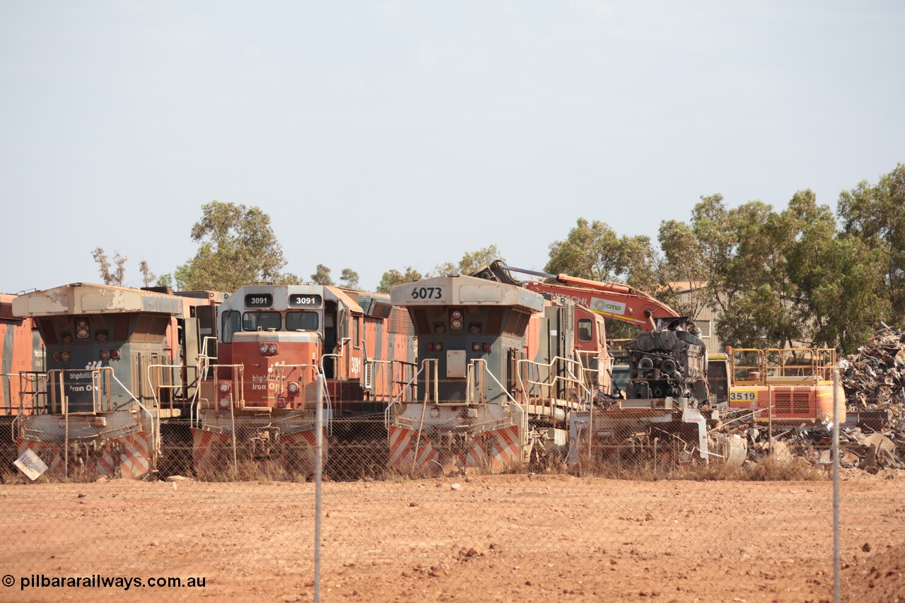 141025 5821
Wedgefield, WA, view from the new bypass road looking into the rear of Sell and Parker's metal recycling yard with former BHP Billiton Iron Ore EMD SD40R and GE AC6000 model units lined up awaiting their fate, from left, AC6000 6075, SD40R 3091, AC6000 6073 and remains of another SD40R.
Keywords: S+P;6073;GE;AC6000;51065;EMD;SD40R;3091;31496/7861-6;