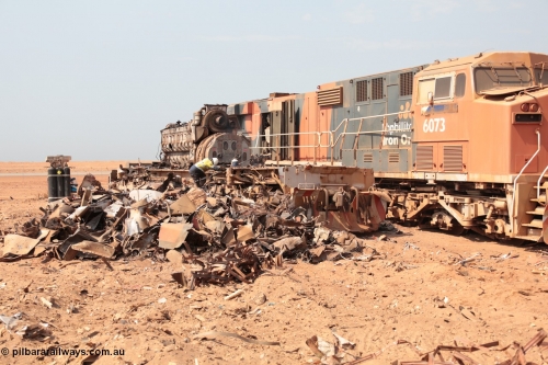 141027 5892
Wedgefield, Sell and Parker's metal recycling yard, a worker steps off the frame of an EMD SD40R with only the EMD 645 engine and alternator intact following thermal lancing to cut the frame up as GE AC6000 unit 6073 looks on.
