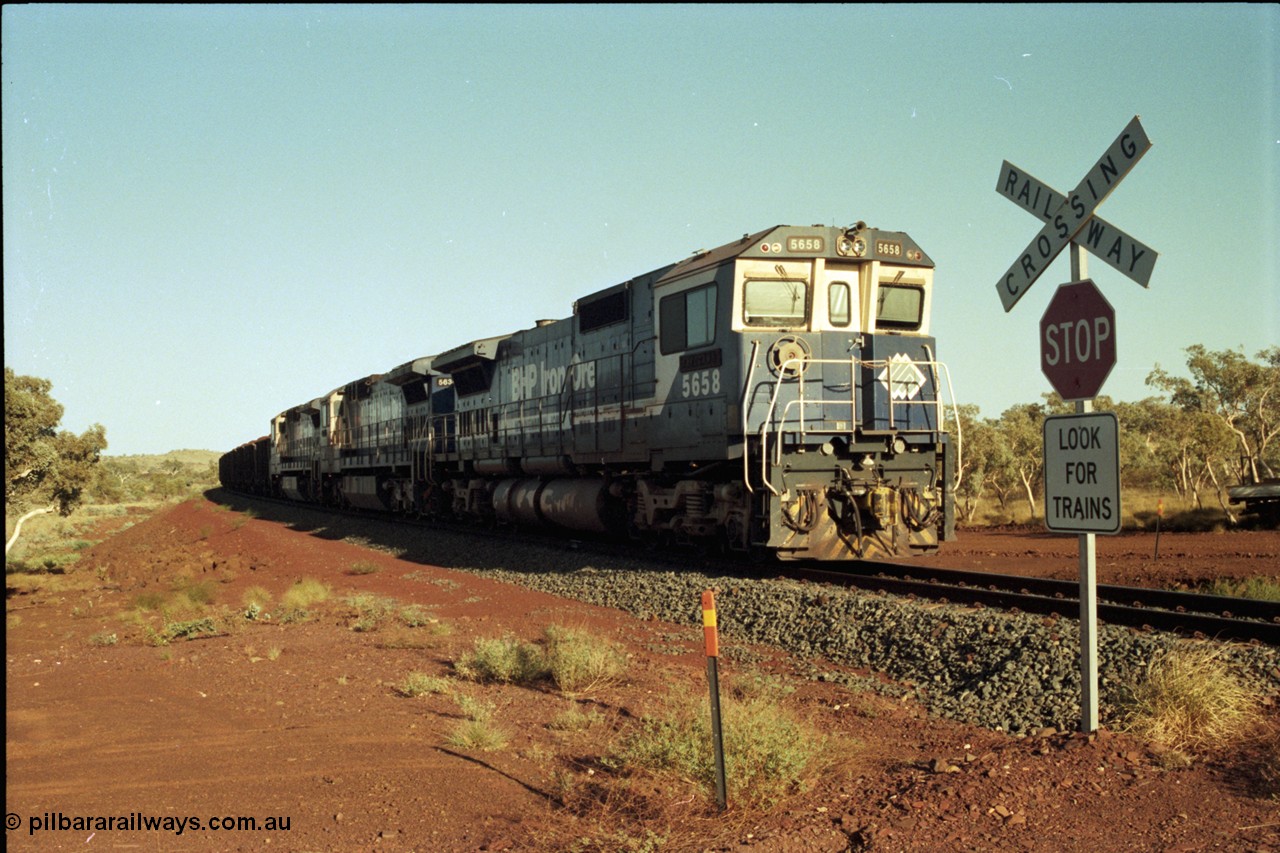 196-02
Yandi Two loaded car side of the loadout balloon loop, BHP Iron Ore CM40-8M or Dash 8 motive power in the form of 5658 'Kakogawa' serial 8412-03 / 94-149 rebuilt by Goninan as GE model CM40-8M from ALCo M636C number 5480 and two new Goninan built GE CM39-8 units 5630 'Zeus' serial 5831-09 / 88-079 and 5631 'Apollo' serial 5831-10 / 88-080 are the head end power with another two CM40-8M units mid-train. Train length is 240 waggons with a 120/120 split. Yandi Two ore stockpile and pedestal stacker boom tip visible in the background, the loadout operates via gravity and the train travels through a tunnel. May 1998.
Keywords: 5658;Goninan;GE;CM40-8M;8412-03/94-149;rebuild;AE-Goodwin;ALCo;M636C;5480;G6061-1;