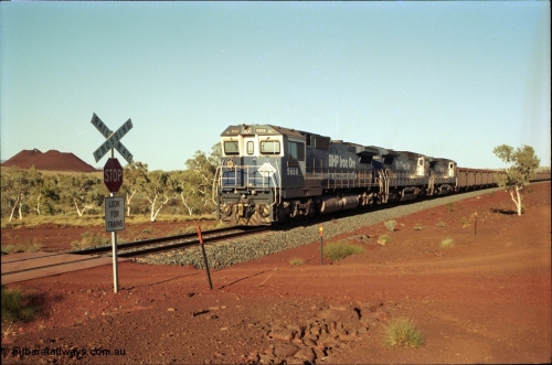 196-01
Yandi Two loaded car side of the loadout balloon loop, BHP Iron Ore CM40-8M or Dash 8 motive power in the form of 5658 'Kakogawa' serial 8412-03 / 94-149 rebuilt by Goninan as GE model CM40-8M from ALCo M636C unit 5480 and two new Goninan built GE CM39-8 units 5630 'Zeus' serial 5831-09 / 88-079 and 5631 'Apollo' serial 5831-10 / 88-080 are the head end power with another two CM40-8M units mid-train. Train length is 240 waggons with a 120/120 split. Yandi Two ore stockpile and pedestal stacker boom tip visible in the background, the loadout operates via gravity and the train travels through a tunnel. May 1998.
Keywords: 5658;Goninan;GE;CM40-8M;8412-03/94-149;rebuild;AE-Goodwin;ALCo;M636C;5480;G6061-1;