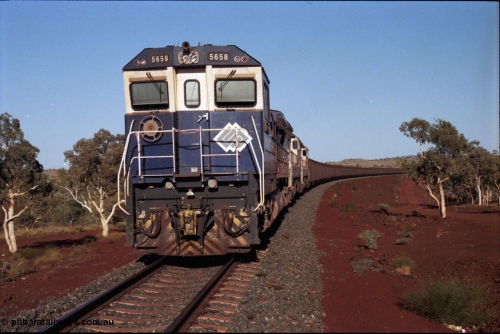 196-09
Yandi Two loaded car side of the loadout balloon loop, BHP Iron Ore CM40-8M or Dash 8 motive power in the form of 5658 'Kakogawa' serial 8412-03 / 94-149 rebuilt by Goninan as GE model CM40-8M from ALCo M636C number 5480 and two new Goninan built GE CM39-8 units 5630 'Zeus' serial 5831-09 / 88-079 and 5631 'Apollo' serial 5831-10 / 88-080 are the head end power with another two CM40-8M units mid-train. Train length is 240 waggons with a 120/120 split. Yandi Two ore stockpile and pedestal stacker boom tip visible in the background, the loadout operates via gravity and the train travels through a tunnel. May 1998.
Keywords: 5658;Goninan;GE;CM40-8M;8412-03/94-149;rebuild;AE-Goodwin;ALCo;M636C;5480;G6061-1;