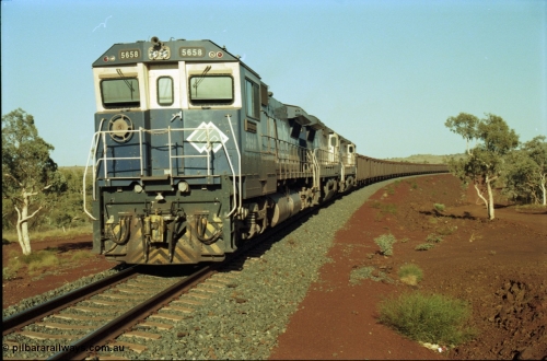 196-12
Yandi Two loaded car side of the loadout balloon loop, BHP Iron Ore CM40-8M or Dash 8 motive power in the form of 5658 'Kakogawa' serial 8412-03 / 94-149 rebuilt by Goninan as GE model CM40-8M from ALCo M636C number 5480 and two new Goninan built GE CM39-8 units 5630 'Zeus' serial 5831-09 / 88-079 and 5631 'Apollo' serial 5831-10 / 88-080 are the head end power with another two CM40-8M units mid-train. Train length is 240 waggons with a 120/120 split. Yandi Two ore stockpile and pedestal stacker boom tip visible in the background, the loadout operates via gravity and the train travels through a tunnel. May 1998.
Keywords: 5658;Goninan;GE;CM40-8M;8412-03/94-149;rebuild;AE-Goodwin;ALCo;M636C;5480;G6061-1;