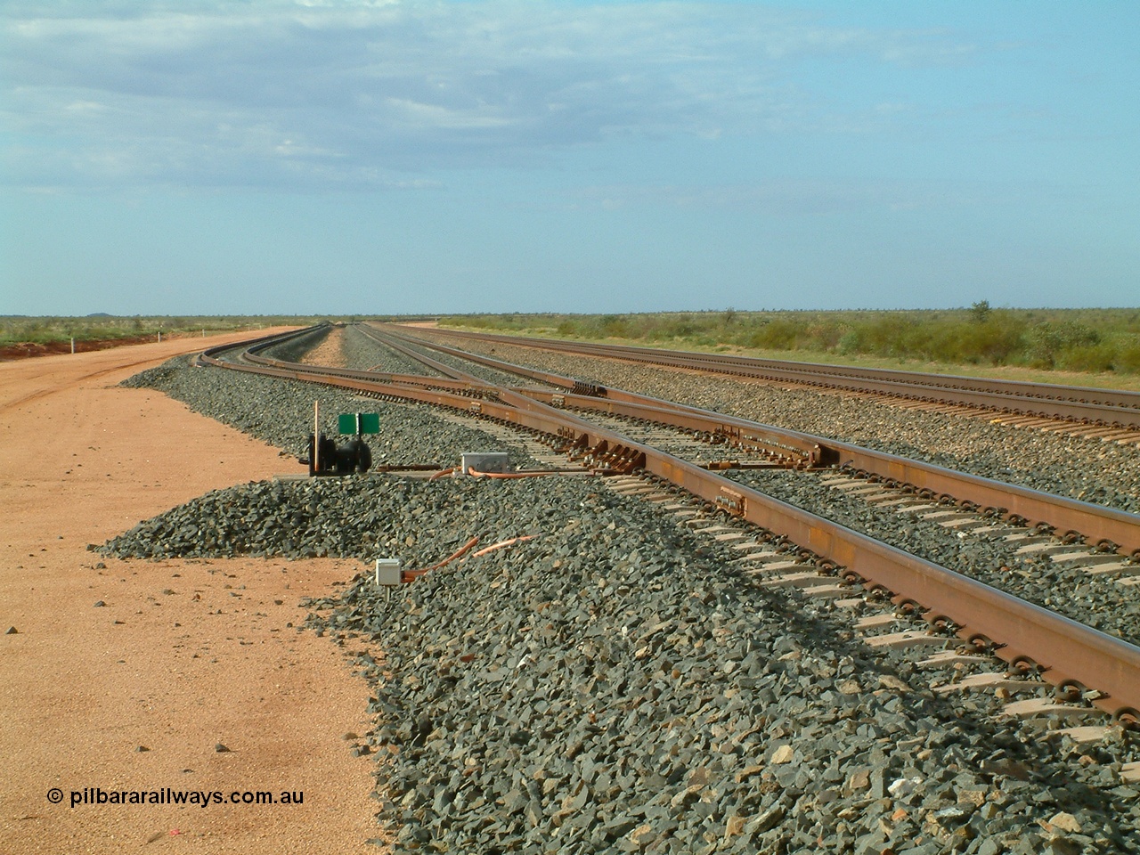 040407 075353
Mooka Siding, looking south with the back track switch and road branching off the passing track, the mainline is on the right. 7th April 2004.
