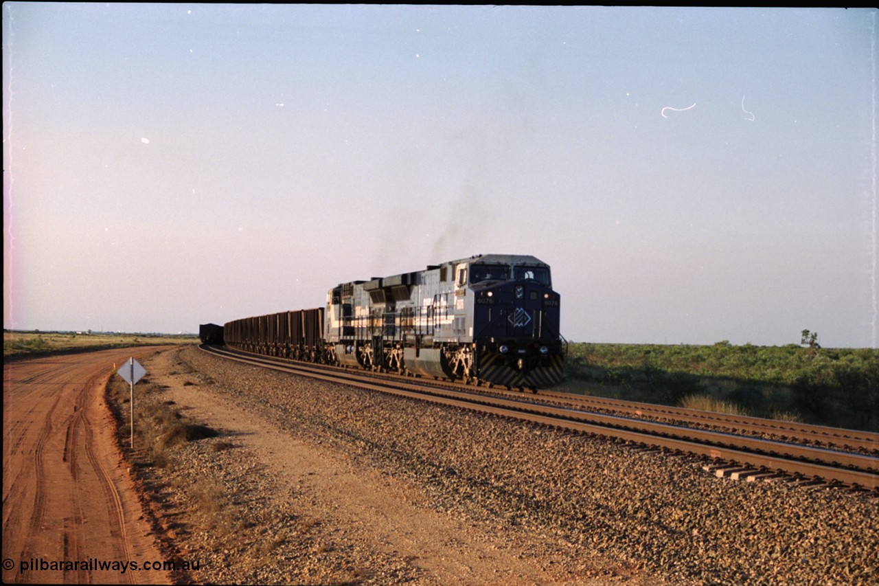 203-02
Bing Siding, an empty train behind BHP General Electric AC6000 unit 6076 'Mt Goldsworthy' serial 51068 runs around the passing track with a loaded train on the mainline.
