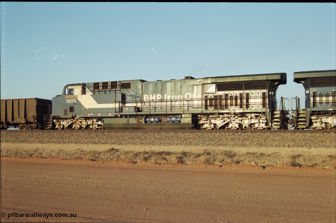 203-04
Bing Siding, BHP General Electric built AC6000 class leader 6070 'Port Hedland' serial 51062 in the passing track as second unit on a Yandi empty working. The size of the BHP AC6000 model radiator is clearly evident here.
Keywords: 6070;GE;AC6000;51062;