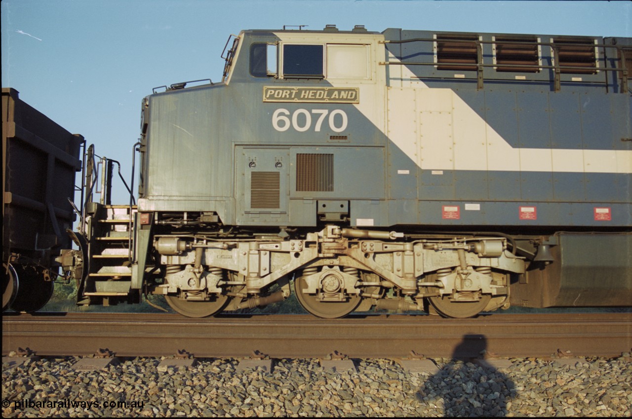 203-06
Bing Siding, BHP General Electric built AC6000 class leader 6070 'Port Hedland' serial 51062 in the passing track as second unit on a Yandi empty working. Cab side view with name board and steerable bogie.
Keywords: 6070;GE;AC6000;51062;