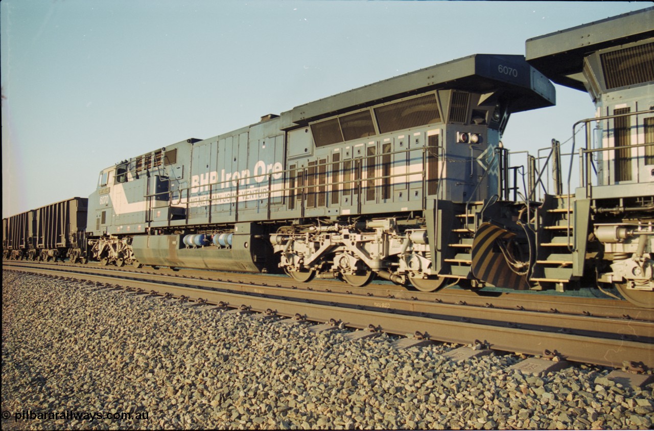 203-10
Bing Siding, BHP General Electric built AC6000 class leader 6070 'Port Hedland' serial 51062 in the passing track as second unit on a Yandi empty working. The size of the BHP AC6000 model radiator is clearly evident here.
Keywords: 6070;GE;AC6000;51062;