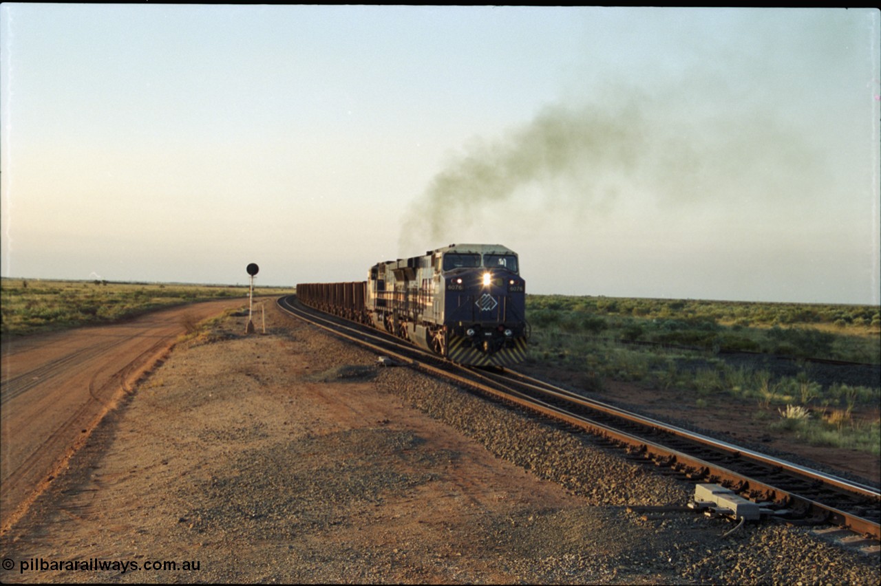 203-19
Bing Siding, with the empty clear, BHP General Electric AC6000 unit 6076 'Mt Goldsworthy' serial 51068 powers its' train out of the passing track at Bing South.
Keywords: 6076;GE;AC6000;51068;