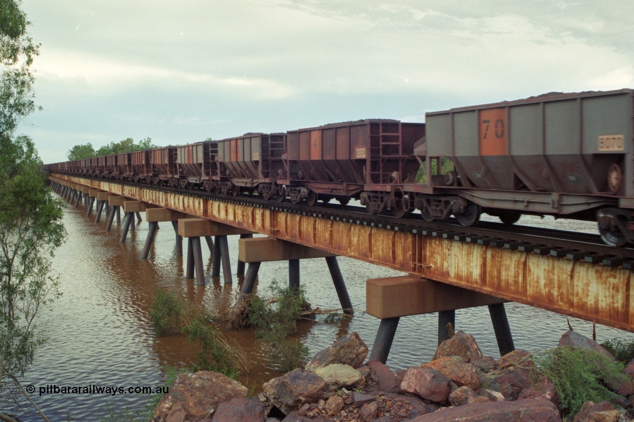 218-15
De Grey River Bridge, a loaded GML train with the original AE Goodwin designed and Tomlinson Steel Perth and Scotts of Ipswich built waggons.
