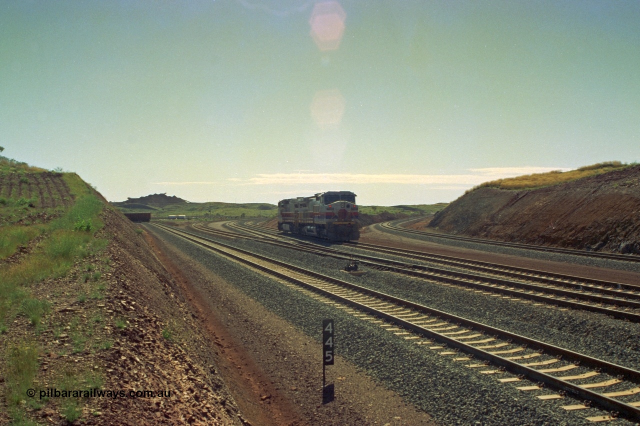 219-01
Yandicoogina or HIY as Hamersley Iron identify it, located 445 km from Parker Point yard in Dampier. Bank engine units General Electric Dash 9-44CW models 7089 serial 47768 and 7090 wait their next loaded train to push out, the tail of which is visible on the left with the mine stockpile in the background.
Keywords: 7089;GE;Dash-9-44CW;47768;