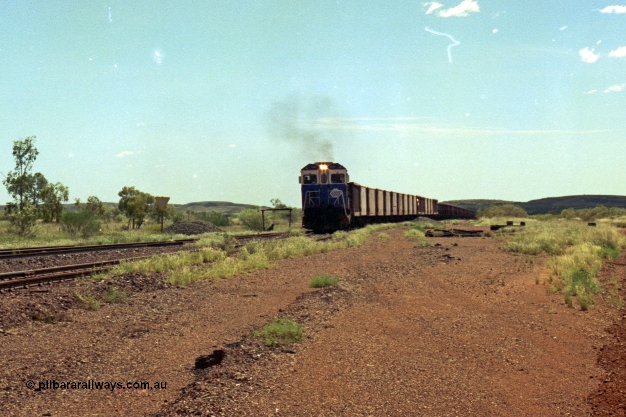 219-27
Goldsworthy Siding, C36-7M unit 5507 'Nimingarra' serial 4839-03 / 87-072, an original Mt Newman Mining ALCo C636 5461 to GE C36-7M rebuild carried out by Goninan, leads an empty train into the siding at Goldsworthy as the second driver watches the roll by under the shade of the shelter.
Keywords: 5507;Goninan;GE;C36-7M;4839-03/87-072;rebuild;AE-Goodwin;ALCo;C636;5461;G6035-2;