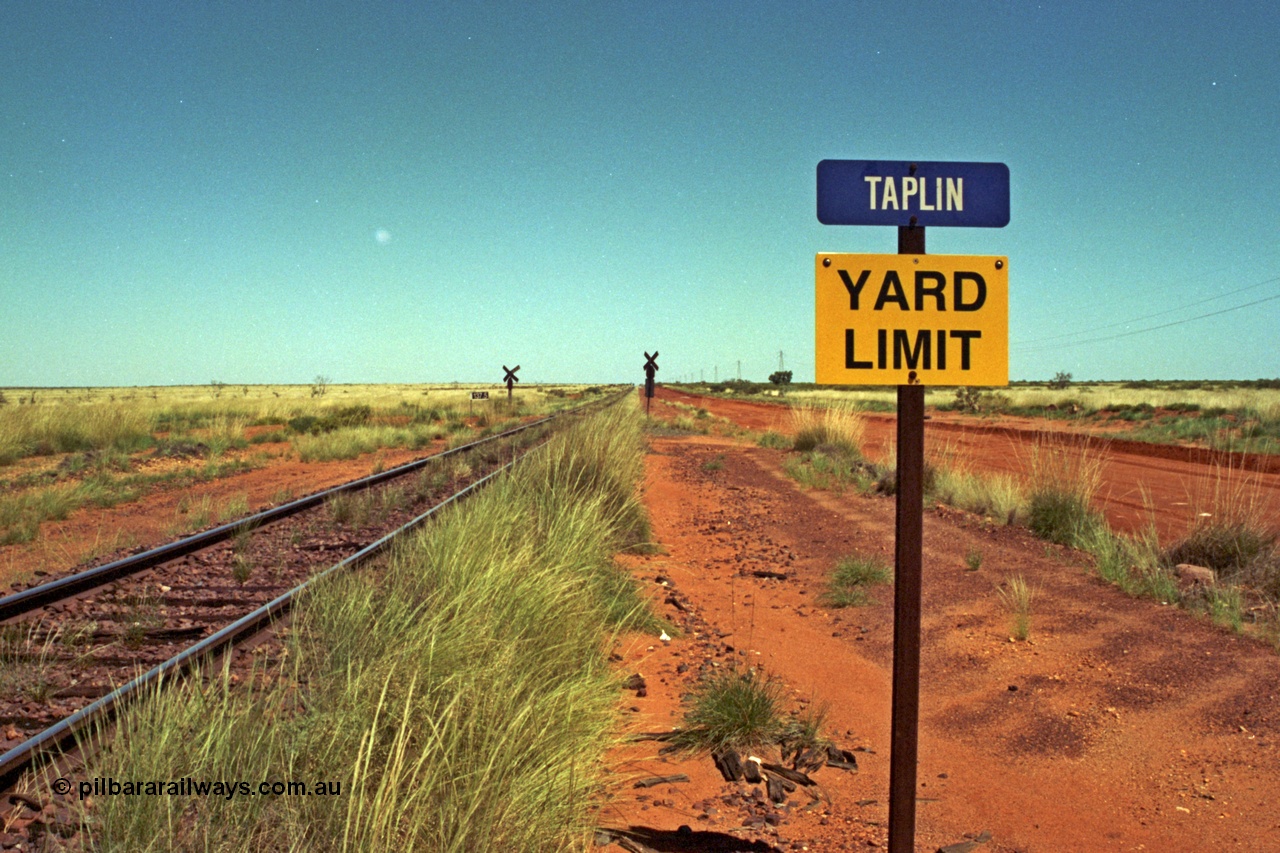 220-05
Taplin Siding, located between the 135 and 137.5 km on the former Goldsworthy Mining Ltd line, now part of the BHP Iron Ore network looking west past the Yard Limit sign and the 137.5 km grade crossing.
