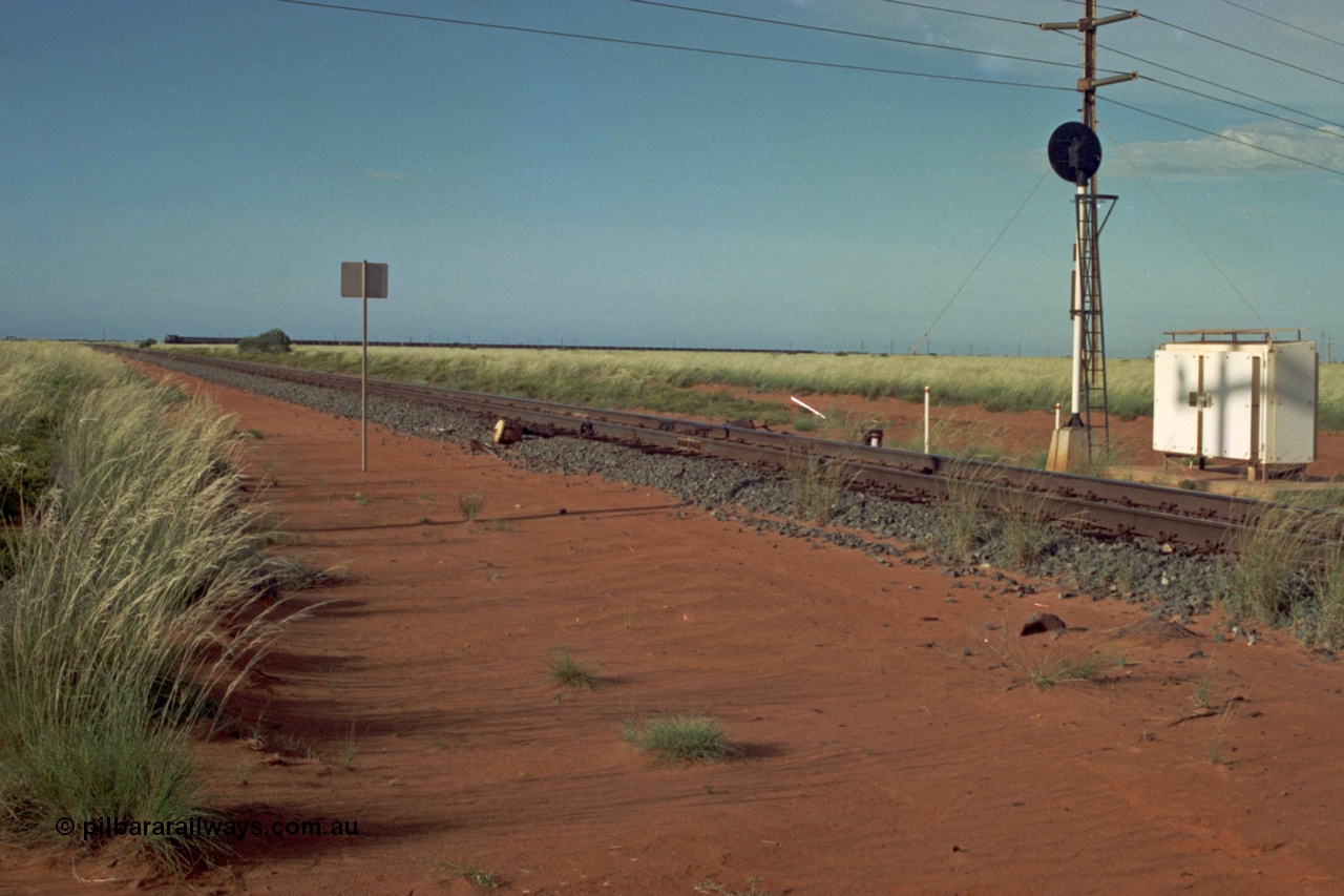 220-20
Goldsworthy Junction, looking north east along the Goldsworthy line as a loaded train ex Yarrie mine approaches rounding the curve, the grease pot for the curve behind the photographer is visible.
