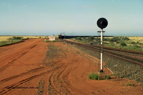 220-28
Goldsworthy Junction, an empty train on the Newman line approaches having departed Nelson Point. The line merging in from the right is the Goldsworthy line to Yarrie and Nimingarra, which can then be made out diverging to the left just after the interlocking room in front of the train.
