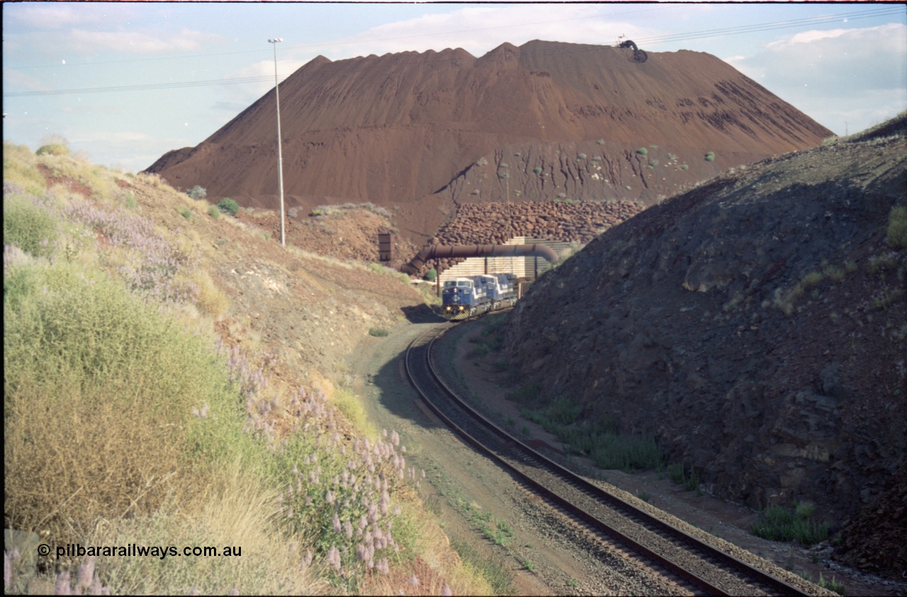 221-27
Yandi One mine loadout balloon loop, a pair of General Electric AC6000 units lead a train being loaded around the balloon, overview of the stockpile with stacker fill the hole from loading.
Keywords: GE;AC6000;51062-9;