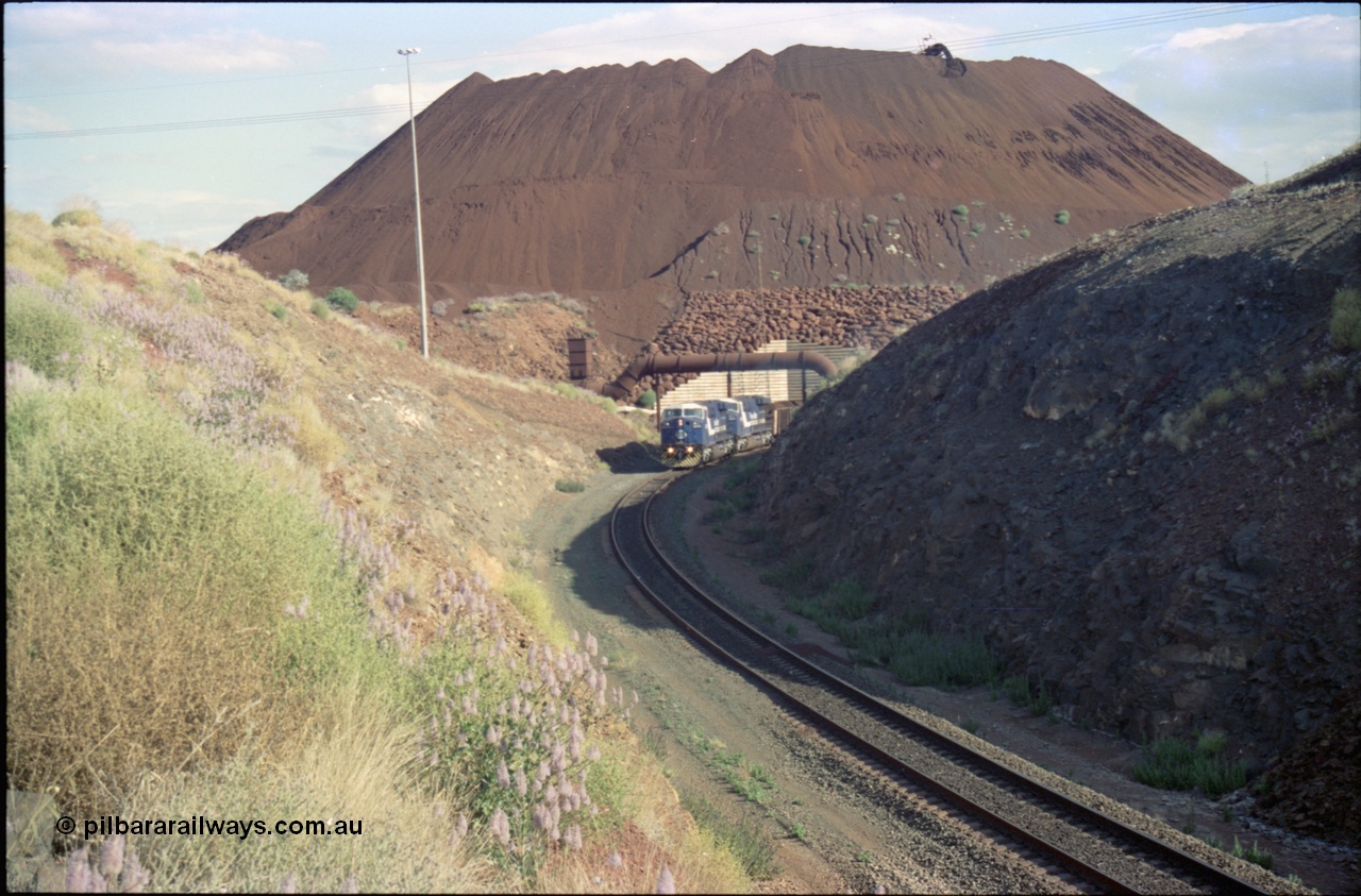 221-28
Yandi One mine loadout balloon loop, a pair of General Electric AC6000 units lead a train being loaded around the balloon, overview of the stockpile with stacker fill the hole from loading.
Keywords: GE;AC6000;51062-9;