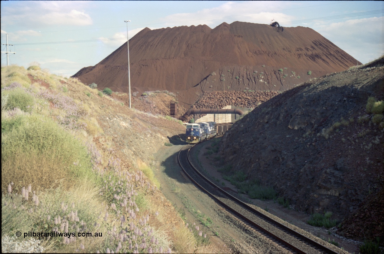 221-29
Yandi One mine loadout balloon loop, a pair of General Electric AC6000 units lead a train being loaded around the balloon, overview of the stockpile with stacker fill the hole from loading.
Keywords: GE;AC6000;51062-9;