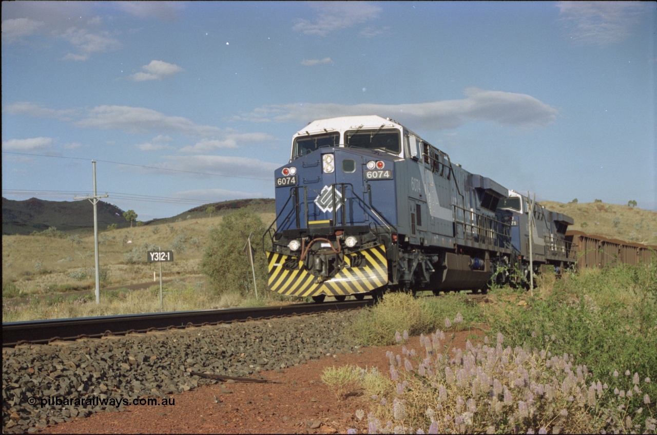 221-31
Yandi One mine loadout balloon loop, near new General Electric AC6000 unit 6074 serial 51066 leads sister unit 6071 serial 51063 at the Y312.1 km crossing while controlling a train being loaded.
Keywords: 6074;GE;AC6000;51066;