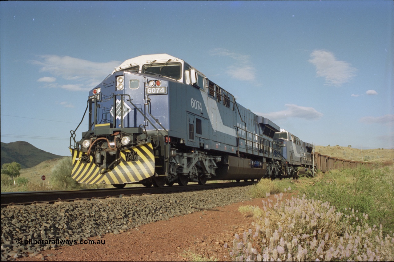 221-33
Yandi One mine loadout balloon loop, near new General Electric AC6000 unit 6074 serial 51066 leads sister unit 6071 serial 51063 at the Y312.1 km crossing while controlling a train being loaded.
Keywords: 6074;GE;AC6000;51066;